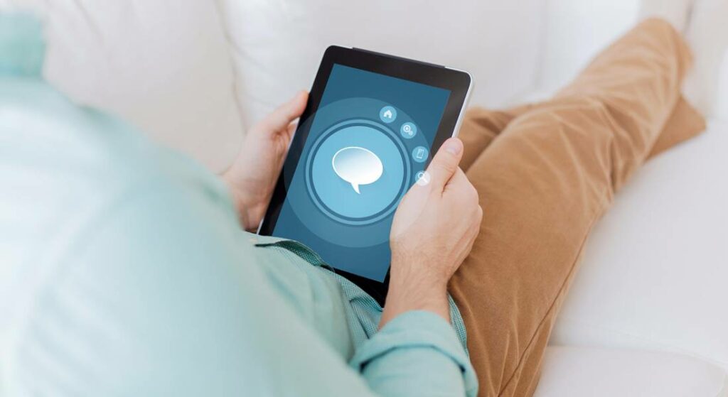 Person using a tablet displaying a chat interface, illustrating digital communication for online businesses and agencies.