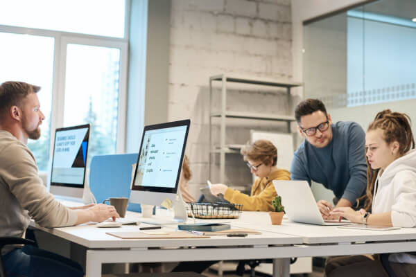 Team collaborating in a modern office setting, focused on digital marketing strategies, with multiple screens displaying data and analytics, emphasizing teamwork and creativity.
