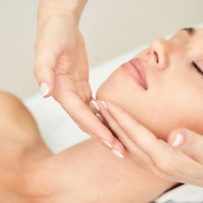 Woman receiving a facial treatment, showcasing relaxation and skincare, relevant to medical spa services like HydraFacials and dermal fillers.