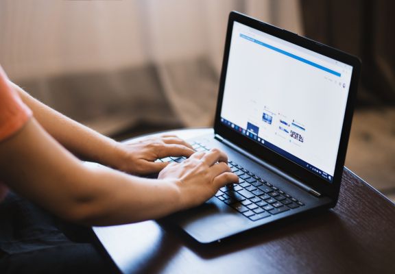 Person typing on a laptop, illustrating digital marketing services and online engagement for Block 24 Marketing.