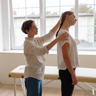 Therapist assisting a client with posture adjustment in a calming therapy room, emphasizing connection and support in mental health practice.