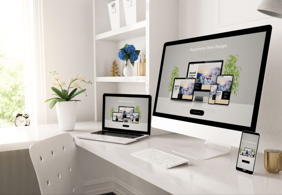Desktop and laptop displaying responsive web design concepts, showcasing various screen sizes and devices, emphasizing user-friendly digital experiences and modern aesthetics in a well-organized workspace.