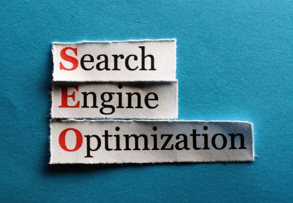 Search Engine Optimization (SEO) text cutouts in black and red on a blue background, highlighting digital marketing services for improving online visibility and search engine rankings.