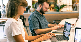 Young professionals working on laptops in a modern café, representing digital engagement and local SEO strategies.